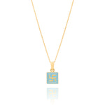 Tiny Jewels gold pendant with a blue square and yellow swastika symbol on a white background