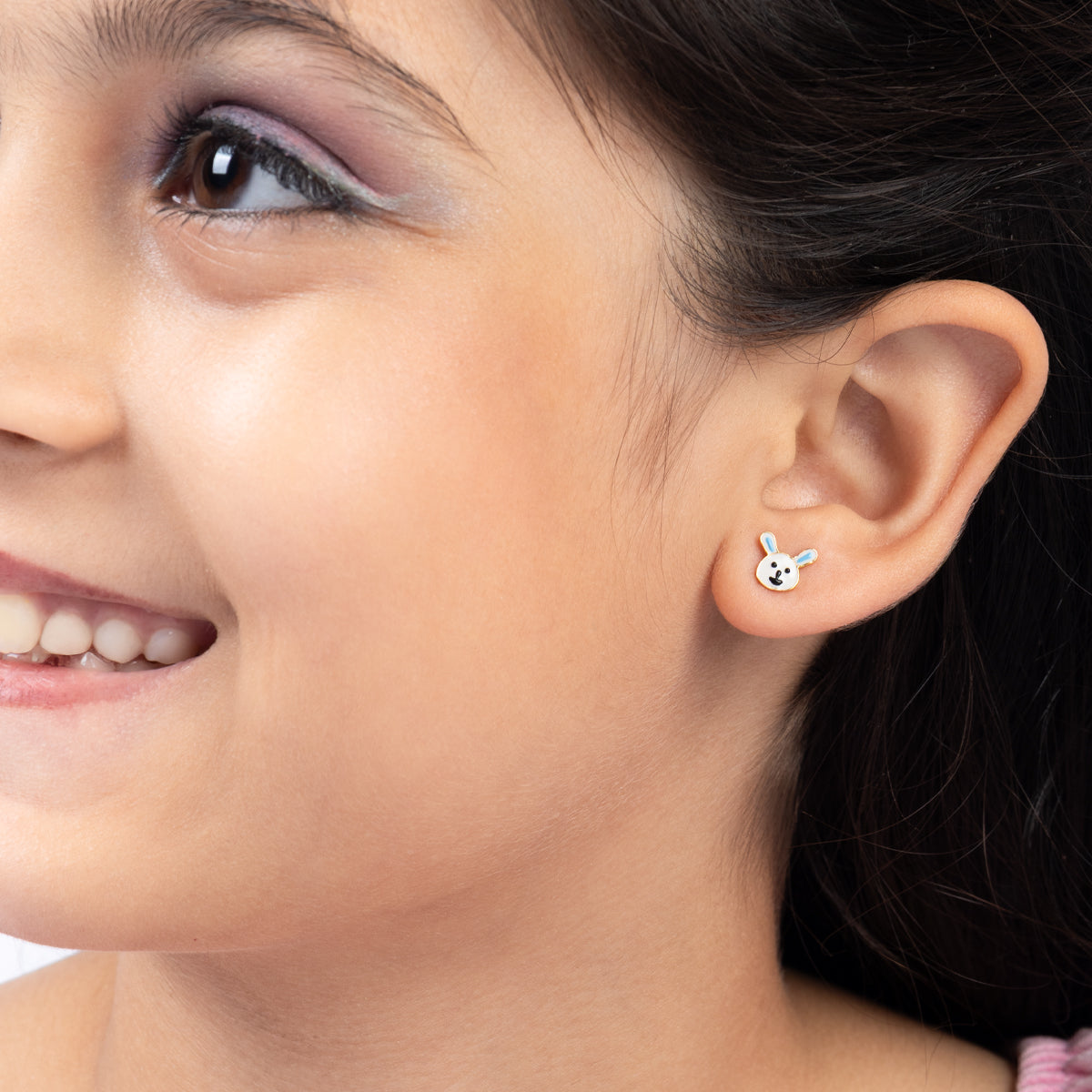 Tiny Jewels close-up of a child wearing a bunny-shaped earring.