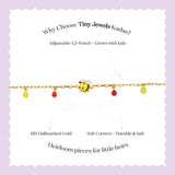 Tiny Jewels bracelet with bee charm on a wrist against a black background 
