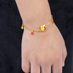 Tiny Jewels bracelet with bee charm on a wrist against a black background 