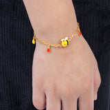 Tiny Jewels bracelet with bee charm on a wrist against a black background 