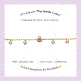 Tiny Jewels gold necklace with colorful charms on a white card with promotional text on a purple background