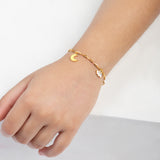 Tiny Jewels gold bracelet with a moon charm on a child's wrist against a white background