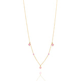 Tiny Jewels gold necklace with pink gemstones on a white background