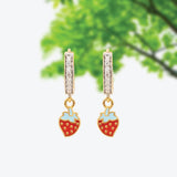 Tiny Jewels gold earrings with strawberry charms on a white background
