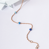 Tiny Jewels necklace with blue beads on a white background