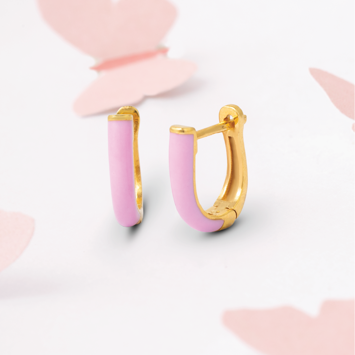 Tiny Jewels pink hoop earrings with gold accents on a light pink background