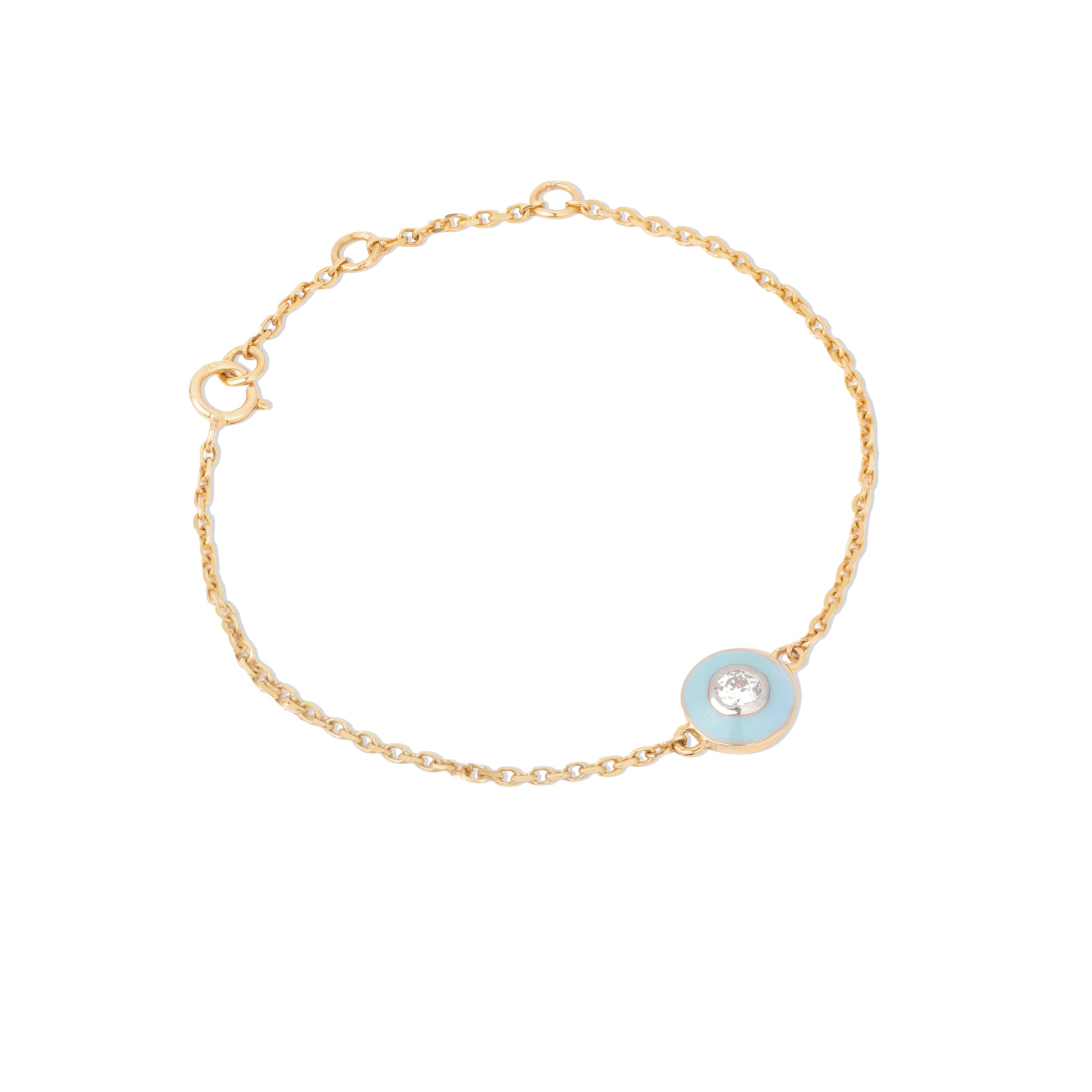 Tiny Jewels gold bracelet with a blue enameled circle and clear gemstone on a white background