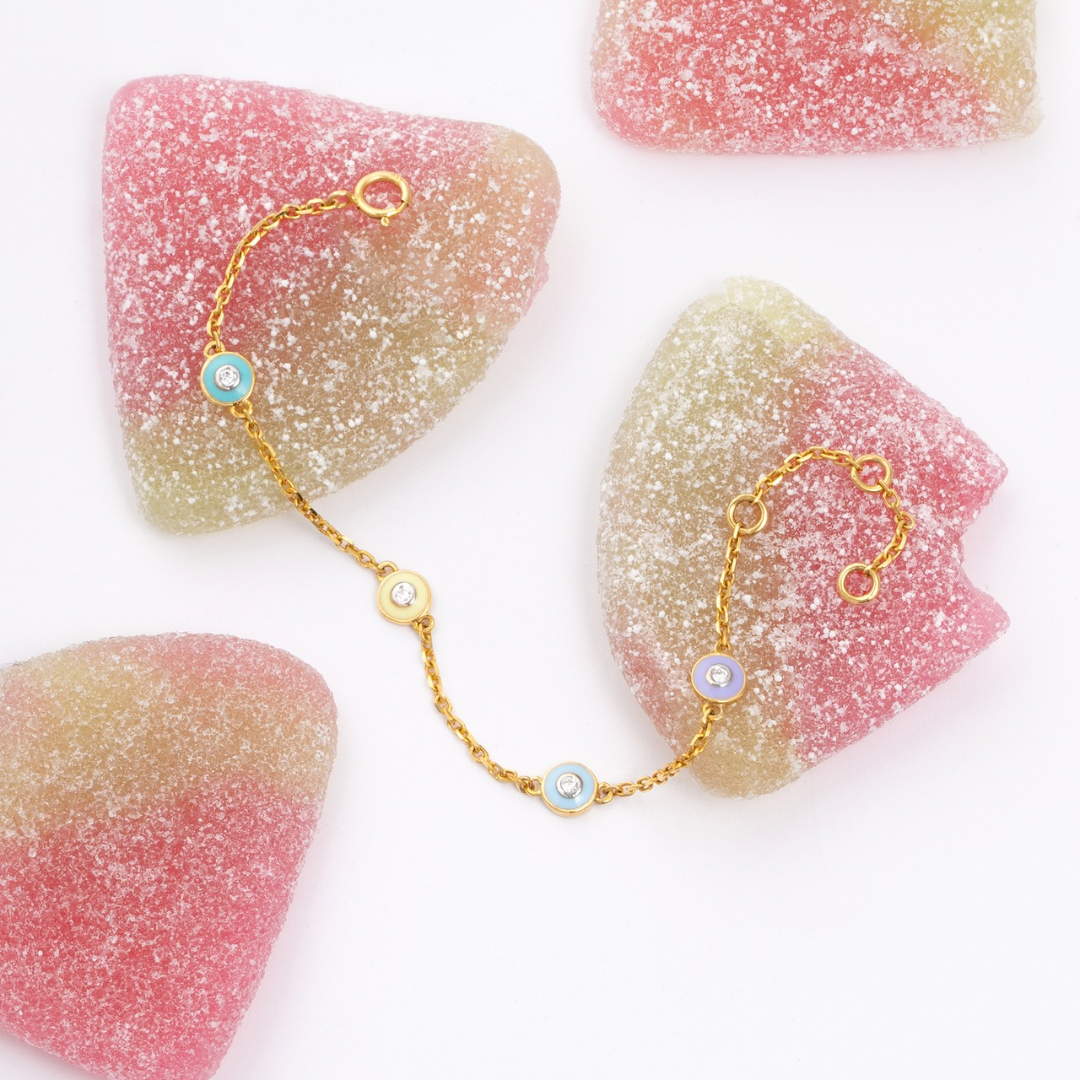 Tiny Jewels gold bracelet with blue beads on a white background