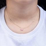 Tiny Jewels necklace with a pink butterfly pendant worn by a person on a white background