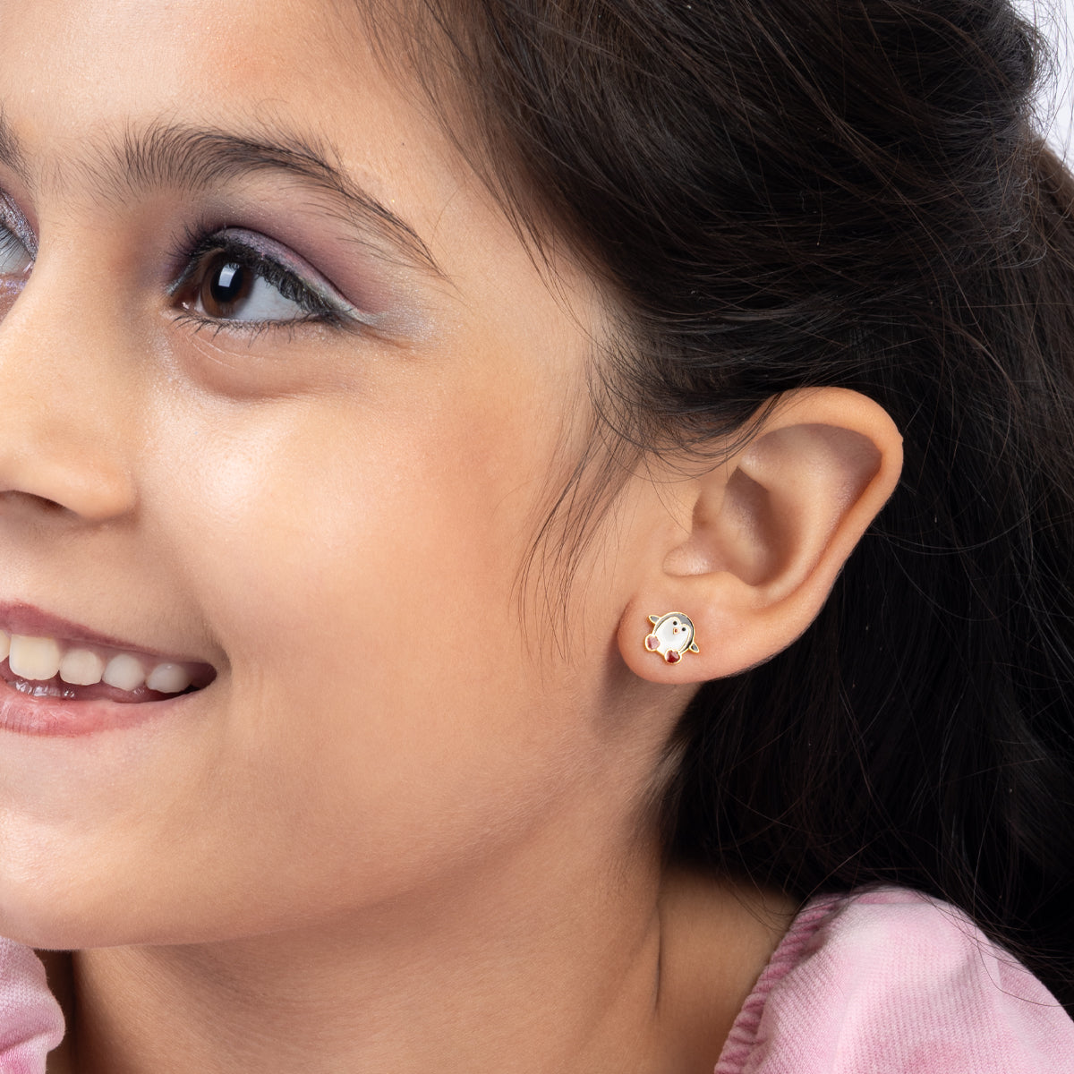 Tiny Jewels close-up of a young girl wearing a small earring with a clear gemstone.