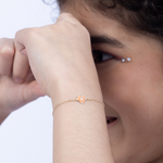 Tiny Jewels close-up of a person wearing a gold bracelet with a heart-shaped charm.