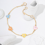 Tiny Jewels gold bracelet with colorful heart-shaped charms on a white background