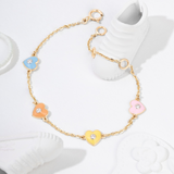 Tiny Jewels gold bracelet with colorful heart-shaped charms on a white background