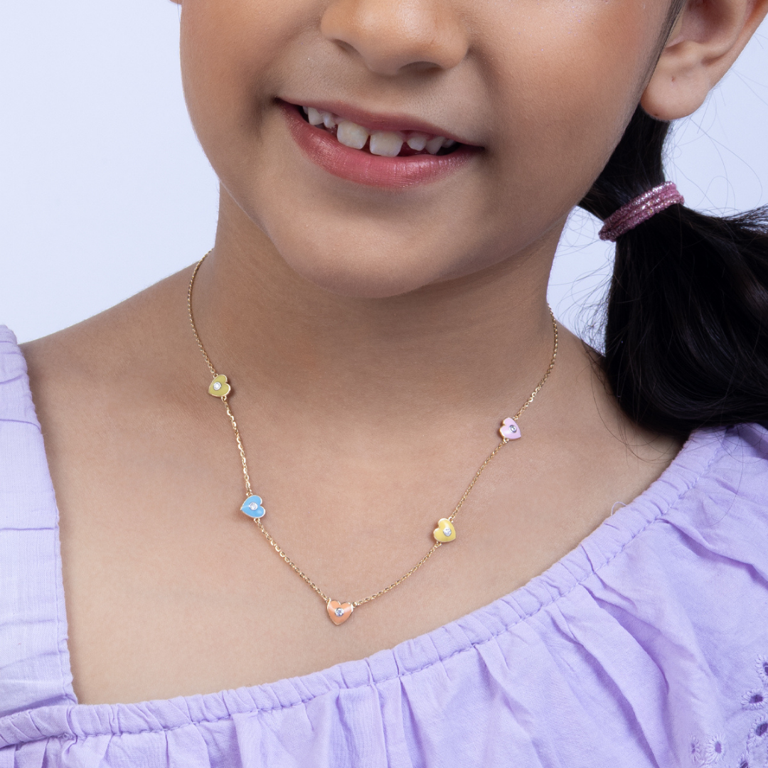 Tiny Jewels child wearing a colorful necklace with a light purple top