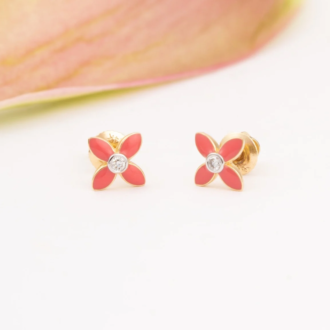 Tiny Jewels flower-shaped earrings with red centers and gold frames on a white background