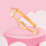 Tiny Jewels gold bracelet with star and cloud designs on a pink cloud background