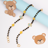 Tiny Jewels necklace with teddy bear design on a light blue and white background