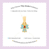 Tiny Jewels gold pendant with blue bow design on a white card with text about Tiny Jewels Pendants.