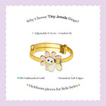 Tiny Jewels gold children's ring with a flower design on a light purple background