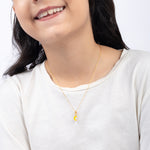 Tiny Jewels Person wearing a gold necklace with a yellow pendant on a white background