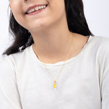 Tiny Jewels Person wearing a gold necklace with a yellow pendant on a white background