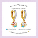 Tiny Jewels gold hoop earrings with cupcake charms on a purple background