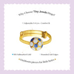 Tiny Jewels gold children's ring with a soccer ball design on a light purple background