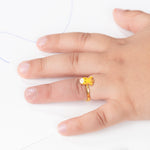 Tiny Jewels gold ring with a cartoon character on a hand against a white background