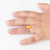 Tiny Jewels gold ring with a cartoon character on a hand against a white background