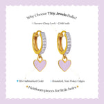 Tiny Jewels gold hoop earrings with heart charms on a light purple background, featuring text about product features.