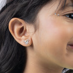 Tiny Jewels close-up of a person wearing a diamond earring.