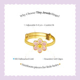 Tiny Jewels gold ring with a pink flower design on a light purple background