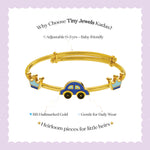 Tiny Jewels gold children's bracelet with car and crown design on a purple background
