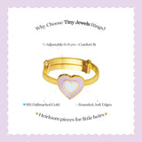Tiny Jewels gold ring with a heart-shaped design on a light purple background
