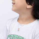 Tiny Jewels person wearing a white shirt with green text and a gold necklace with a pendant.