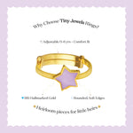 Tiny Jewels gold ring with a purple star-shaped stone on a light purple background with text about the ring's features.