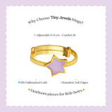 Tiny Jewels gold ring with a purple star-shaped stone on a light purple background with text about the ring's features.