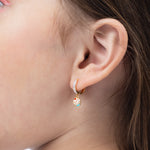 Tiny Jewels close-up of a child's ear wearing a colorful earring.