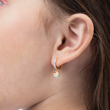 Tiny Jewels close-up of a child's ear wearing a colorful earring.
