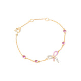 Tiny Jewels gold bracelet with pink and clear gemstones on a white background