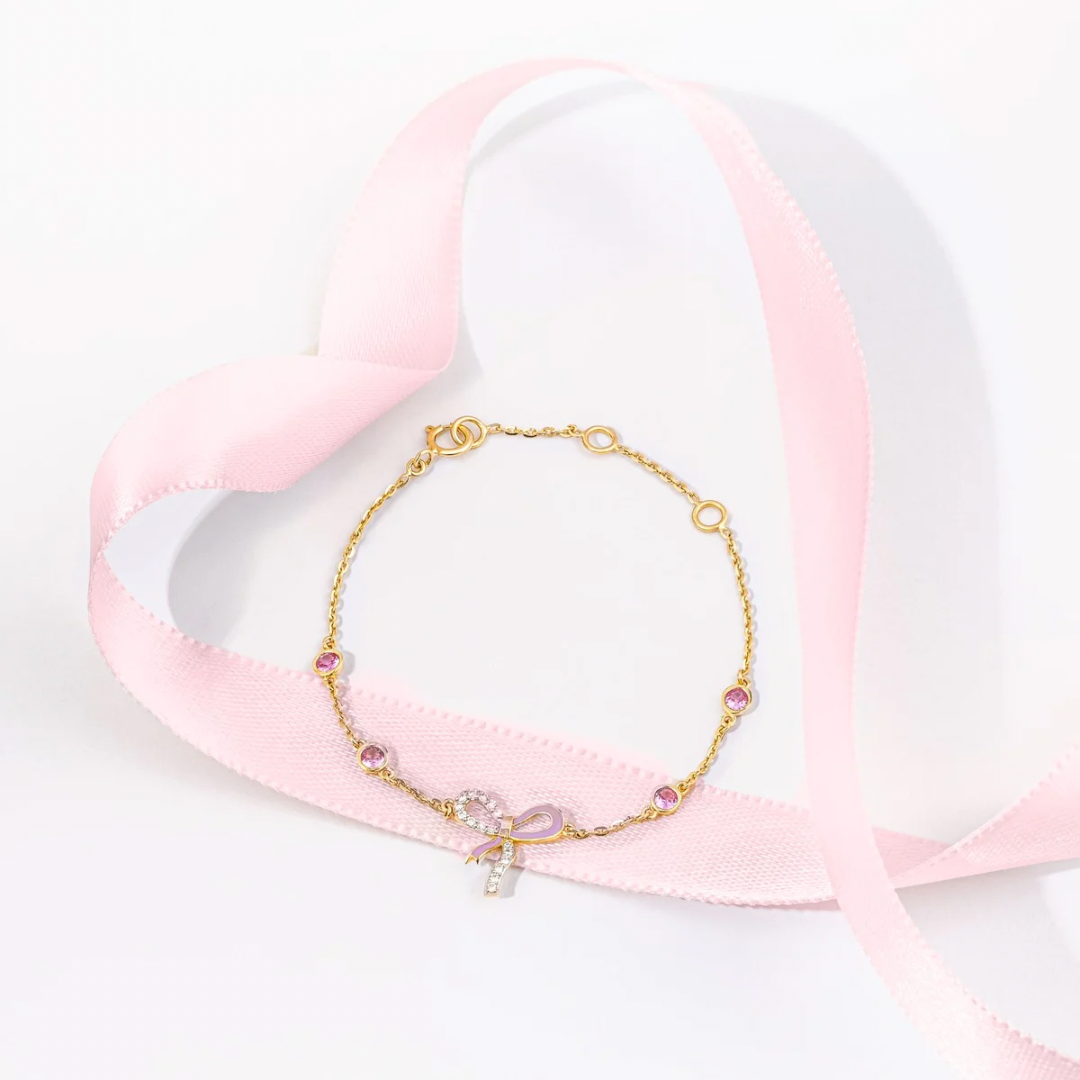 Tiny Jewels gold bracelet with pink beads on a heart-shaped pink pillow