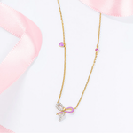 Tiny Jewels gold necklace with a bow pendant on a white background