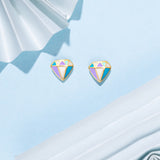 Tiny Jewels colorful gemstone earrings on a light blue fabric background