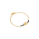 Tiny Jewels gold bracelet with black beads on a white background
