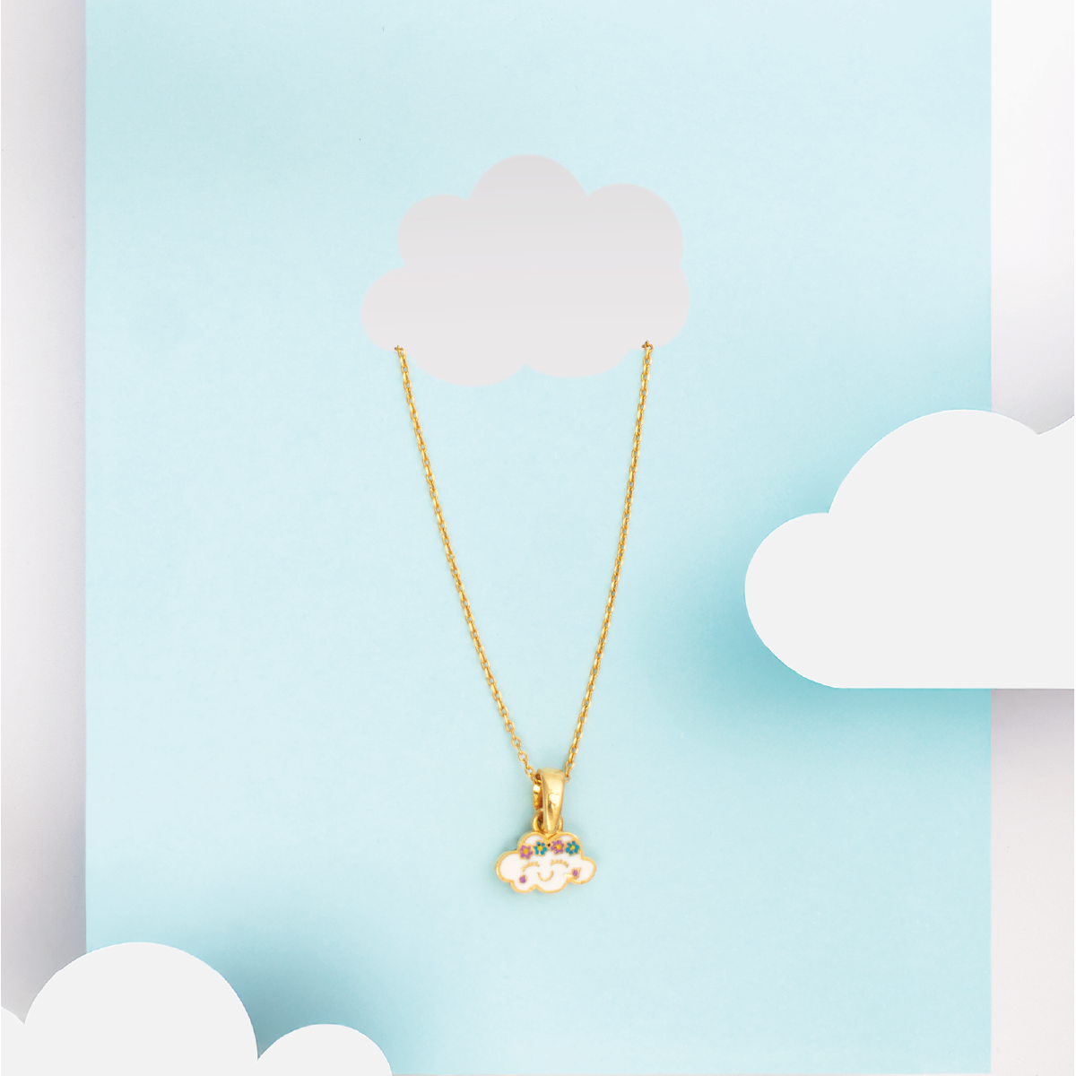 Tiny Jewels gold necklace with a cloud-shaped pendant on a light blue background with white clouds.