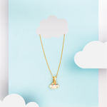 Tiny Jewels gold necklace with a cloud-shaped pendant on a light blue background with white clouds.