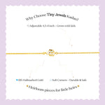 Tiny Jewels gold bracelet with a small owl charm on a child's wrist against a white background
