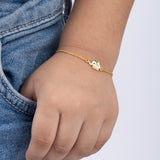 Tiny Jewels gold bracelet with a small owl charm on a child's wrist against a white background