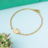 Tiny Jewels gold bracelet with a heart-shaped charm on a light blue background
